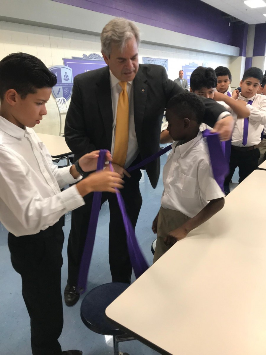 Mayor Adler helps sixth-grade students learn to tie their ties for the first time